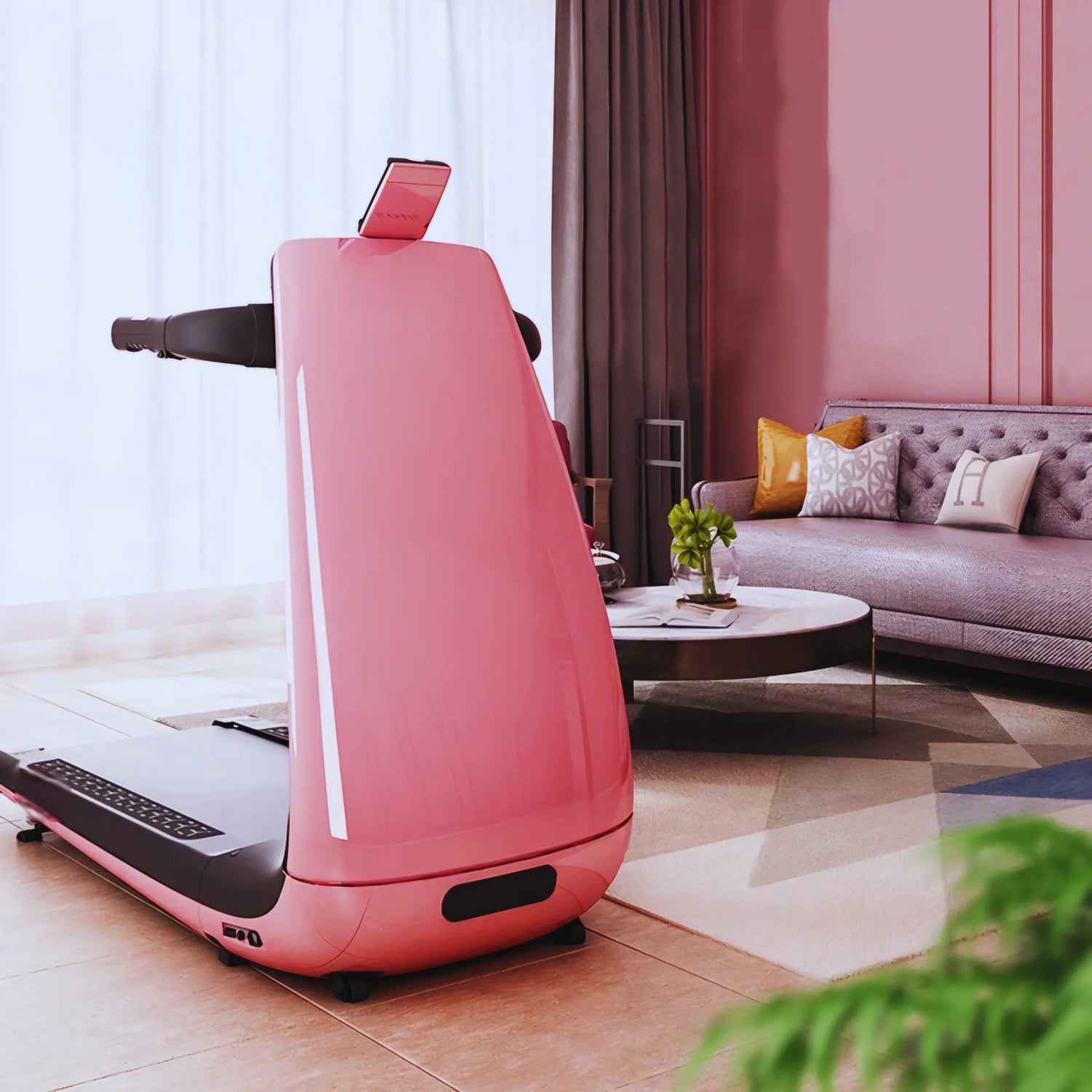 Modern pink treadmill in stylish living room with sofa, pillows, and coffee table